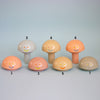 Set of colorful mushroom-shaped figurines with smiley faces on a light blue background