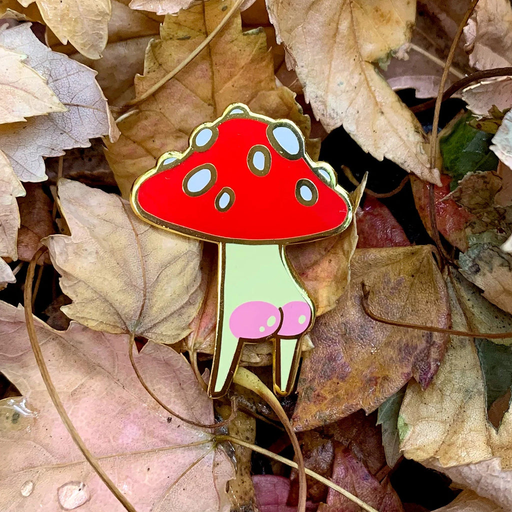 Mushroom-shaped pin on a bed of autumn leaves