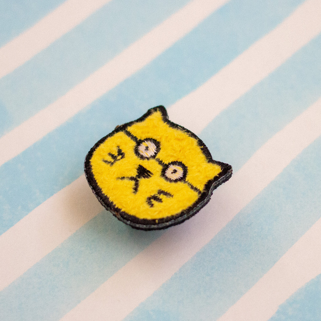 Yellow cat-shaped patch on a striped background