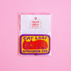 An embroidered patch featuring a sleeping orange cat on a yellow background with purple text reading 'CAT LOAF APPRECIATION CLUB' and a purple border, attached to a white backing card with the brand 'Yan Yan Candy Ng' visible, set against a solid pink background.