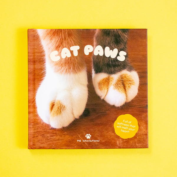 Book cover with cat paws on a wooden floor against a yellow background