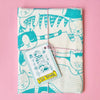 Tea towel with cat pattern and matching tag on a pink background