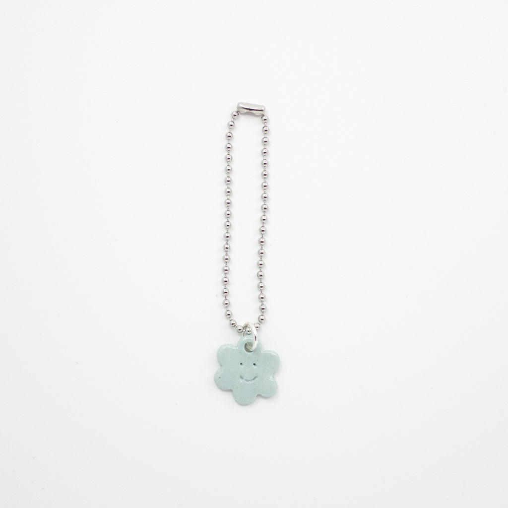 Necklace with a light blue cloud-shaped charm on a white background