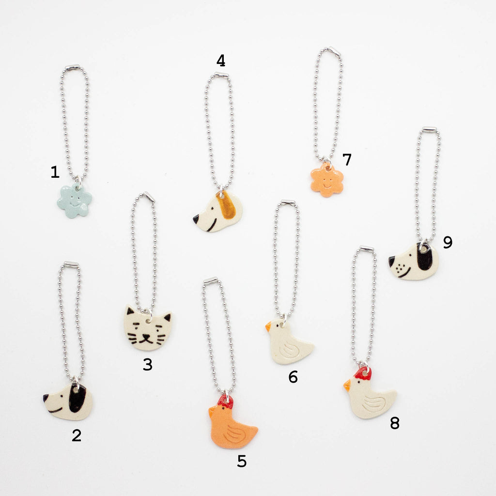 Set of animal-themed bag charms on white background