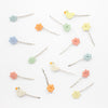 Set of colorful hairpins with floral, cloud, and bird designs on a white background