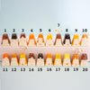 Twenty small ceramic volcano-shaped items with painted faces and different hair colours, arranged in two rows on a pale blue background with black numbers 1 through 20 above them.