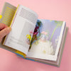 Open book with colourful illustrations on a pink background