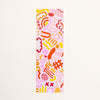 A rectangular bookmark featuring a playful abstract pattern in pink, orange, yellow, and red on a light cream background.