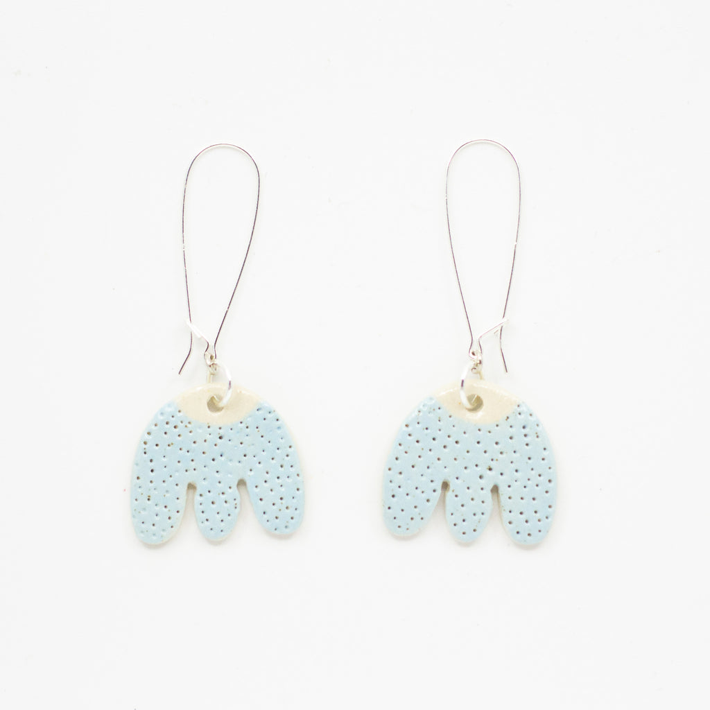 Pair of light blue earrings with textured design on a white background