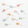 Set of colorful heart and star-shaped hairpins on a white background