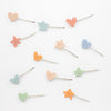 Set of colorful heart and star-shaped hairpins on a white background
