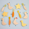 Set of magnetic ceramic figures including birds, carrots, and stars on a light blue background