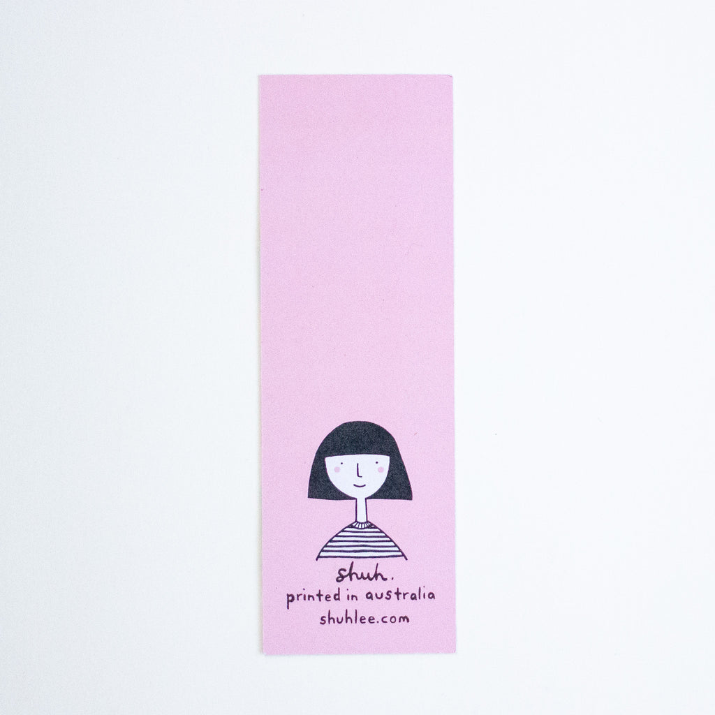 A tall, narrow pink bookmark featuring a simple black line drawing of a person with short dark hair and the text 'shuh. printed in australia shuhlee.com' near the bottom, shown on a plain white background.