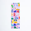 A tall, narrow rectangular bookmark with a light pink background covered in a colourful pattern of whimsical cartoon shapes and faces, shown against a plain white background.