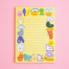 A yellow lined notepad with whimsical cartoon character illustrations around the border, photographed on a soft pink background. The brand name 'shuh.