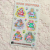 A sticker sheet titled 'CUTIE CRITTERS' featuring six cute pixel-art animal characters in pastel clothing, placed on a textured cream lace fabric background. 