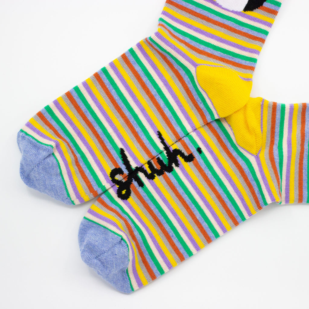 Closeup Side view of the shuh. cutie socks. Bright striped background with shuh. girl face. Yellow heel. 