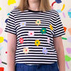 Front view of the Daisies tee. Black and white striped tee, with multicolour daisies printed on the front. 
