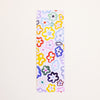 A rectangular bookmark with a colourful floral pattern on a white background, photographed flat against a light off-white backdrop.