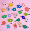 Colourful flower-shaped objects with numbers on a pink background