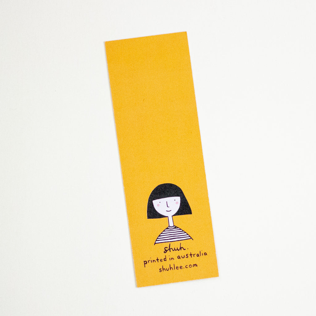 A tall, narrow mustard bookmark with a simple black line drawing of a person and the text 'shuh. printed in australia shuhlee.com'