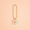 Flower-shaped keychain with a pink center on a peach background