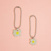 Two flower-shaped keychains on a peach background