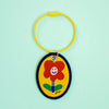Keychain with a red flower design on a light green background