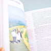 An open book showing printed text and a map, photographed close up with a blurred yellow foreground element at the bottom right.