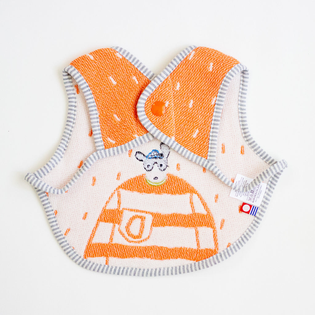 A baby bib with a bright orange and white striped pattern, featuring a cartoon dog character wearing a  sweater and a grey and white striped border.