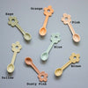 Set of colorful flower-shaped spoons on a gray background with color labels.