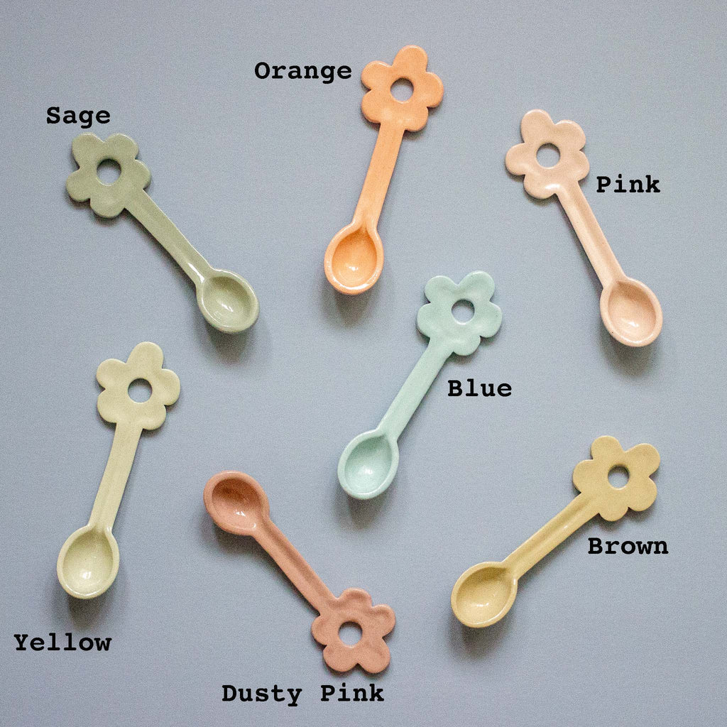 Set of colorful flower-shaped spoons on a gray background with color labels.