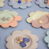 Floral-shaped jewelry holders with earrings on a light blue background
