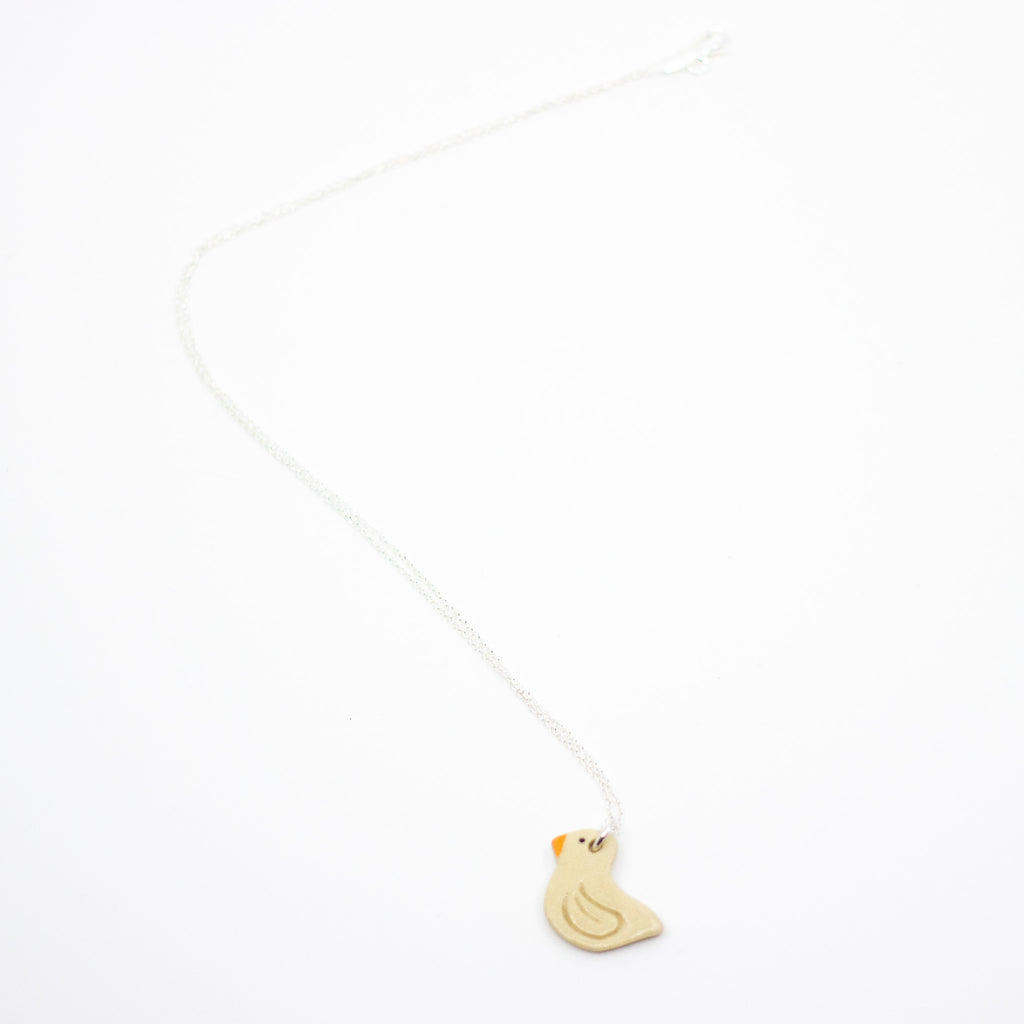 Beige Duck shaped pendant on a silver chain against a white background