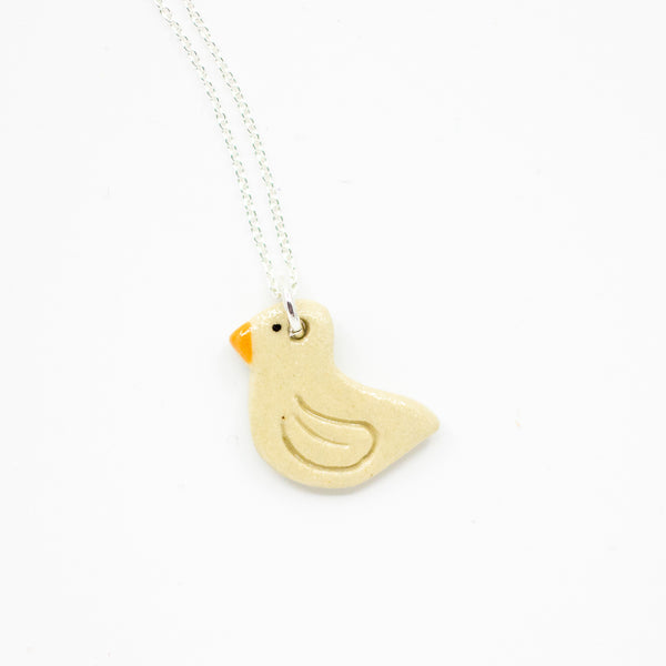 Beige Duck-shaped pendant on a silver chain against a white background