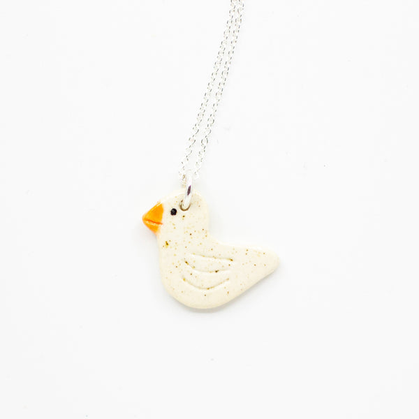 White Duck-shaped pendant on a chain against a white background