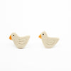 Two white bird-shaped earrings on a white background