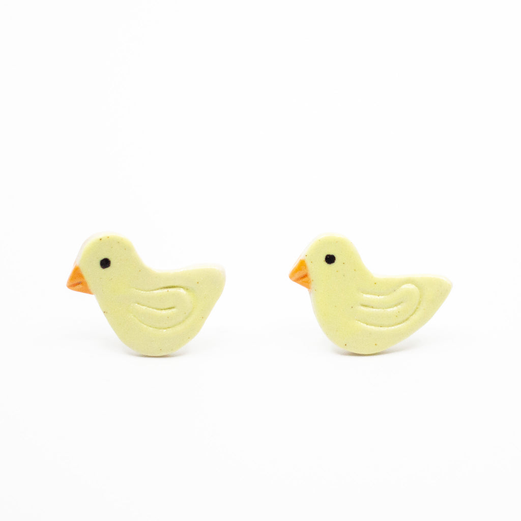 Pair of yellow duck-shaped earrings on a white background