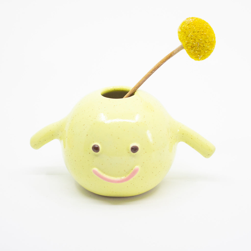 A front view of the Esme Vase, holding a flower. Yellow Speckled. 