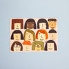 A postcard featuring a grid of twelve stylised cartoon faces with diverse hair, skin tones, and glasses, displayed against a solid light blue background.