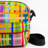 Colorful plaid-patterned bag with a black strap on a white background