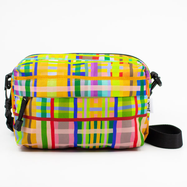 Colorful plaid patterned bag with black straps on a white background