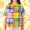 A front view of the shuh Farm print linen top. Multicoloured lines in grid patterns resembling a birds eye view of a farm. 