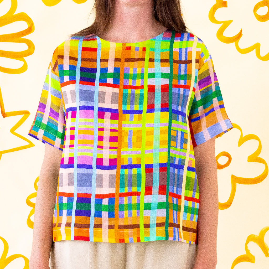 A front view of the shuh Farm print linen top. Multicoloured lines in grid patterns resembling a birds eye view of a farm. 