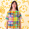 A full view of the shuh Farm print linen top. Multicoloured lines in grid patterns resembling a birds eye view of a farm. 