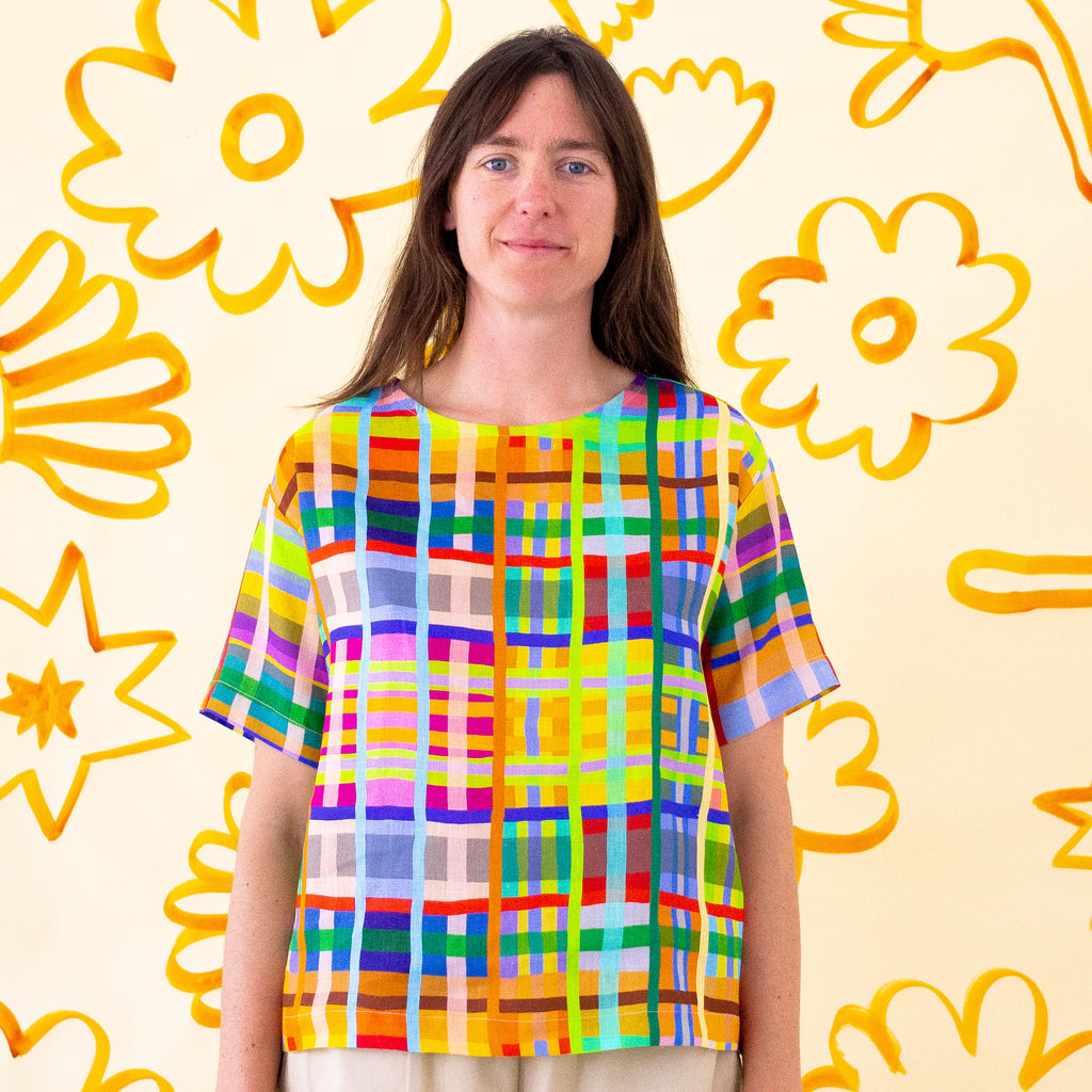 A full view of the shuh Farm print linen top. Multicoloured lines in grid patterns resembling a birds eye view of a farm. 