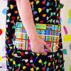 A person carrying the farm useful bag. Multicoloured lines in grid patterns. 