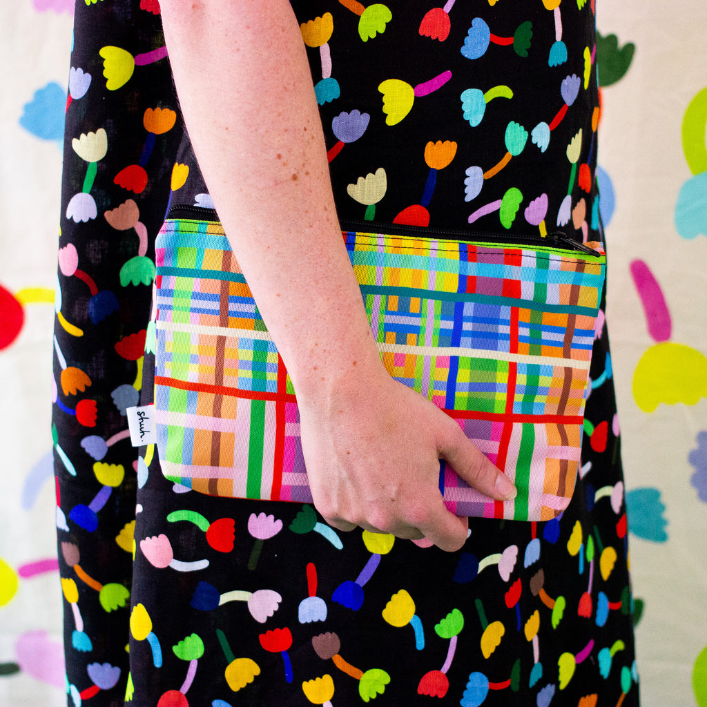 A person carrying the farm useful bag. Multicoloured lines in grid patterns. 
