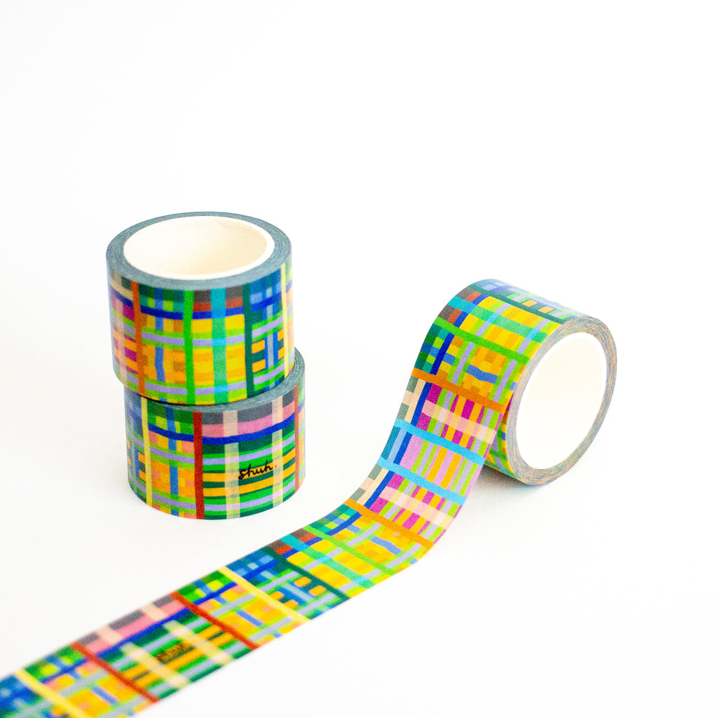 Three rolls of colorful plaid-patterned tape on a white background