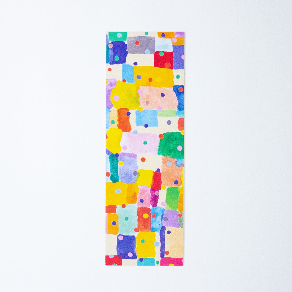 A long bookmark featuring a colourful abstract geometric pattern of painted blocks and dots on a white background.